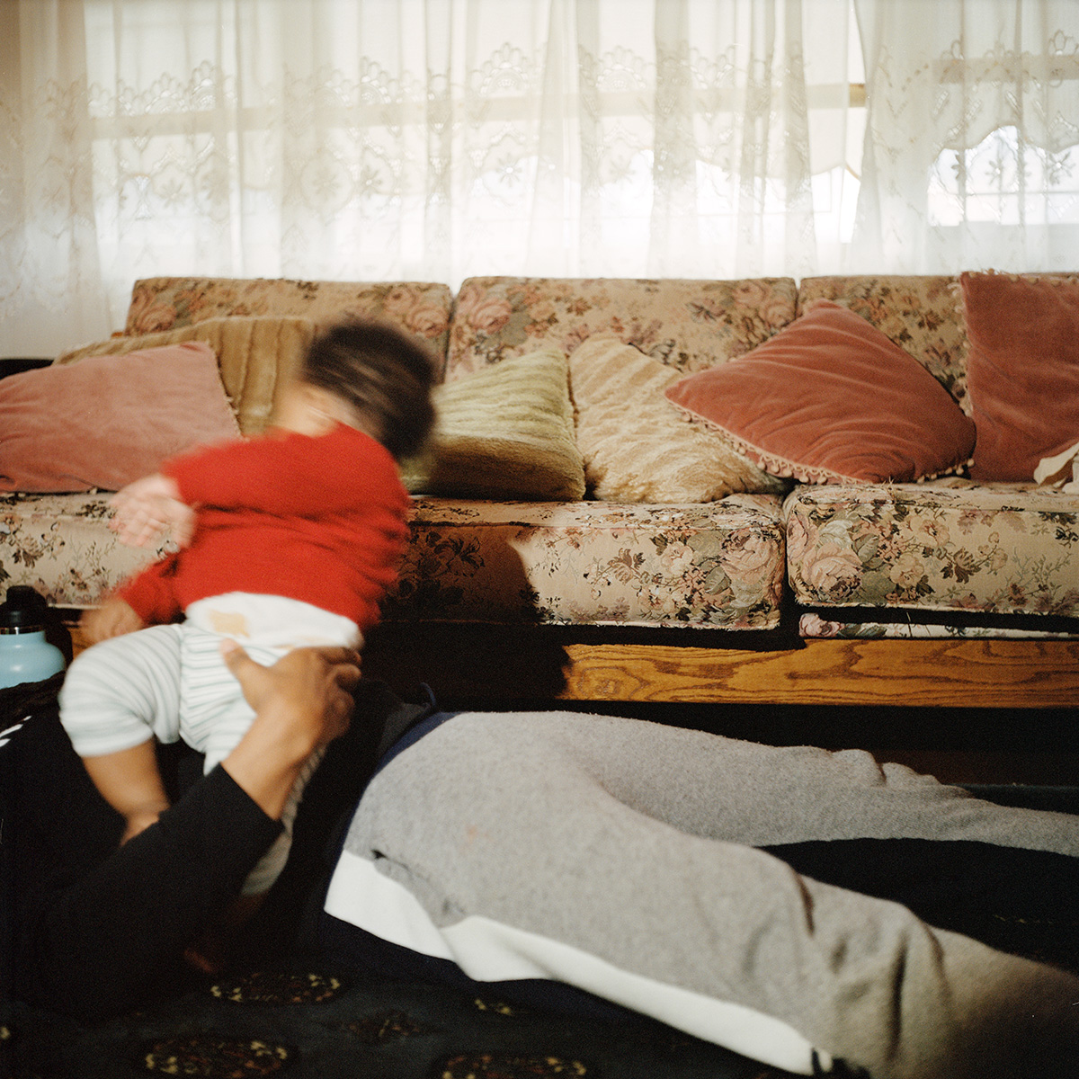 Person resting on a couch wearing a red shirt
