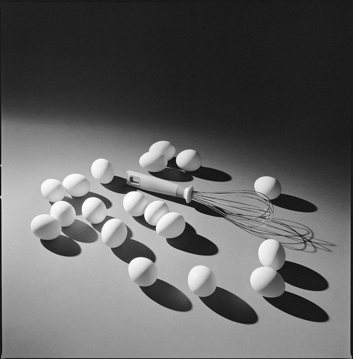 Still life photograph of eggs, a whisk, and kitchen objects