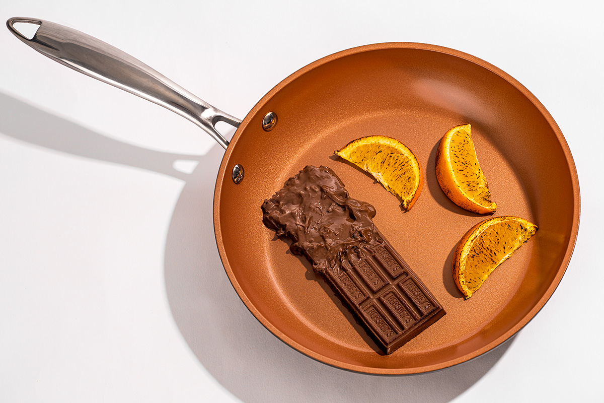 Still life photograph of chocolate and orange in a pan