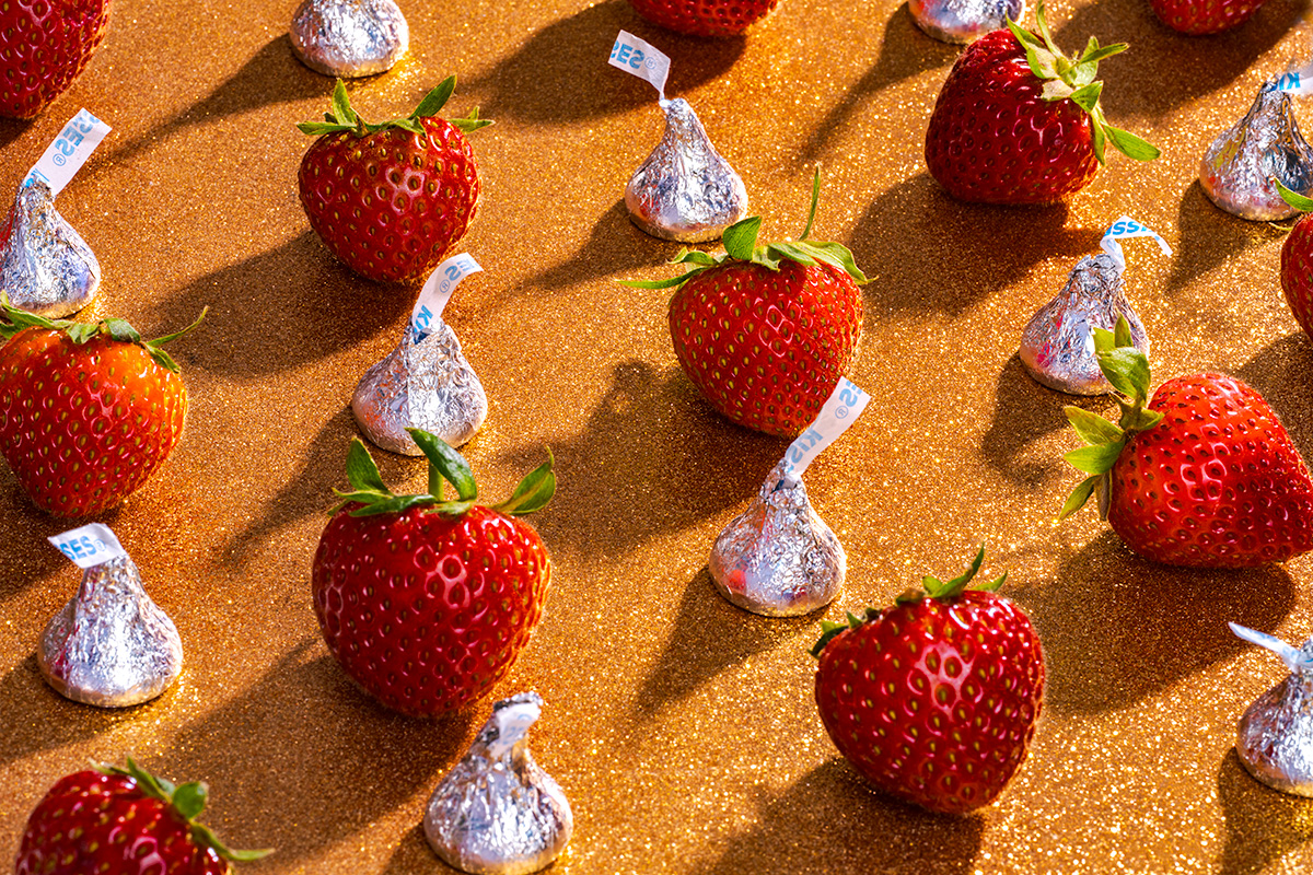 Still life photograph of strawberries and wrapped chocolate